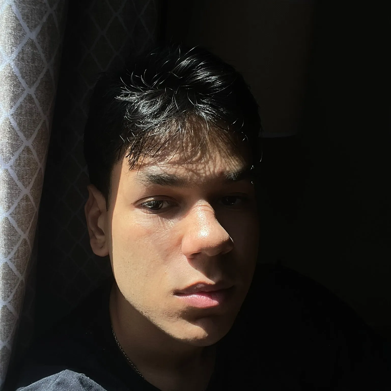 Portrait of Marcello Valente in window light, his face half in shadow